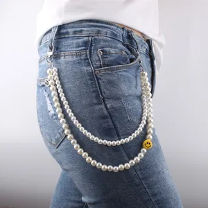 Dubbellaagse parelketting voor de taille met geel smiley-icoon op een blauwe jeans