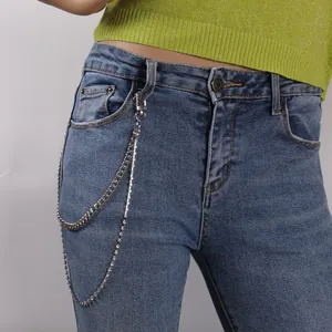 Catena per il corpo a due strati argentata con strass su jeans blu con passante