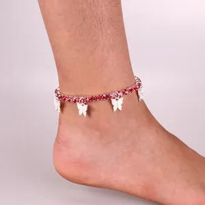 Close-up of pink rhinestone anklet featuring four silver butterfly charms on woman's ankle