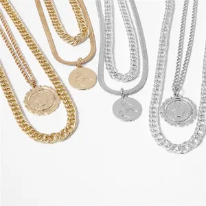 Detailed macro view of layered cuban and snake chains with vintage coin pendants