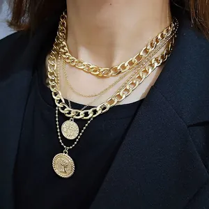 Three-layer gold necklace with coin pendants and queen relief on a model wearing black