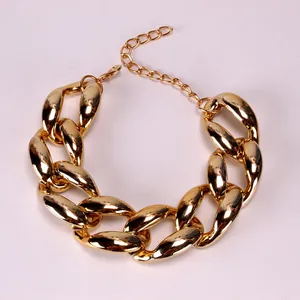 Détail d'un collier à grosse chaîne dorée avec fermoir mousqueton et finition polie brillante