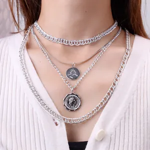 Retro multilayer silver Cuban chain necklace set with vintage coin pendant on white knitwear