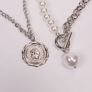 Detailed close-up of Baroque pearl necklace with vintage silver coin and OT toggle clasp