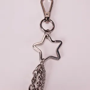Macro shot of silver metal star keychain with multi-layer tassel chains and lobster clasp