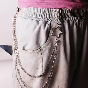 Detail of silver multi-layer metal trousers chain with star pendant on denim jeans