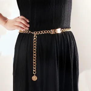 Vintage goldene Kettengürtel mit Löwenkopf-Plakette und Münzanhänger auf Kleid