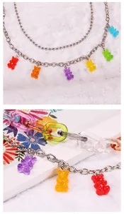 Detailopname van kleurrijke harsbeertjes aan een gelaagde metalen hiphop broekketting