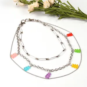 Three-layer silver chain necklace featuring six colorful resin gummy bear pendants