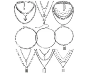 Dettaglio di nove collane color argento con pendenti a cuore, lucchetto e croce in set