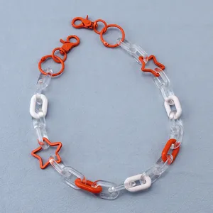Detail of street style resin pant chain with orange and clear hollow stars and lobster clasp