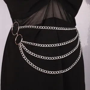 Silver multi-layer waist chain with metal rings and fringe over a black dress