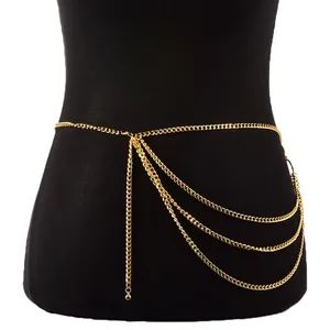 Detail of a layered gold metal body chain featuring tiered fringes and ball charms