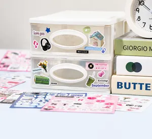 Détail d'une boîte de rangement blanche à deux couches avec des autocollants déco