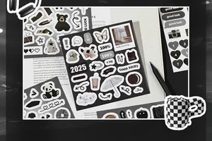 Detail of minimalist black and white stationery stickers on a notebook with desk accessories