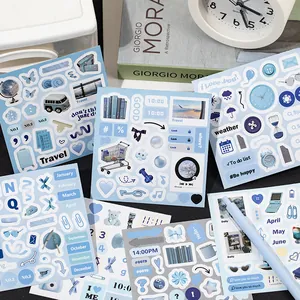 Morandi blue deco sticker book set with travel and daily motifs on a black desk