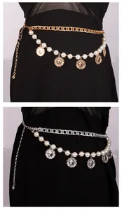 Detail van vintage muntbedels en imitatieparels op een dubbellaagse metalen tailleketting