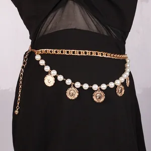 Vintage gouden tailleketting met parels en muntbedeltjes op een zwarte jurk