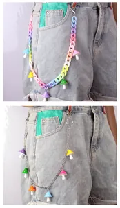 Detail of colorful acrylic and metal pants chains with mushroom charms on denim shorts