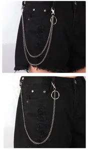 Detail of silver layered metal hip-hop chains on distressed black denim shorts with rings