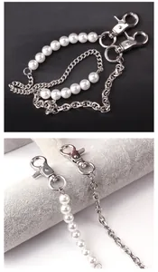 Detail of U-shaped body chain featuring faux pearls and silver metal links with lobster clasp