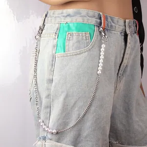 Retro U-shaped body chain with faux pearls on denim jeans for a stylish layered look