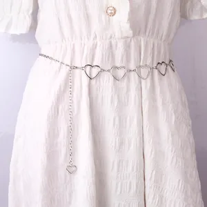Silver multi-layered heart-shaped metal waist chain on a white dress for punk hip-hop style