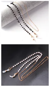 Detail of eyewear chains with black beads and white pearls on golden metal links