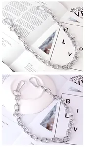 Detail of silver metal hip hop pant chain featuring dual spring snap hook buckles
