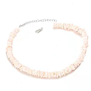 Detail van handgemaakte schelpenketting met roze steentjes en zilveren karabijnsluiting