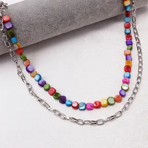 Dettaglio della catena in vita a doppio strato con perle di conchiglia iridescenti e anelli