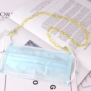 Detail shot of yellow acrylic glasses chain with clear lobster hooks on a magazine background