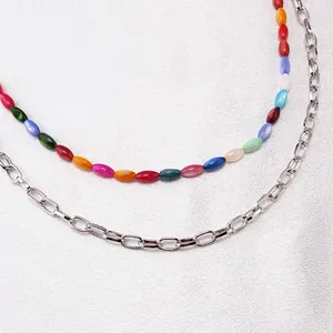 Dettaglio di perle colorate e catena a graffetta d'argento su una catena a doppio strato