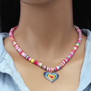 Detail of bohemian rainbow heishi bead necklace with layered heart pendant on a model