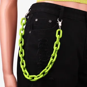 Detail van de neon-groene grove acryl ketting op zwarte jeans voor punk straatstijl