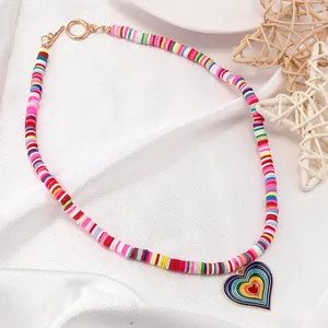Detail of bohemian rainbow heishi bead necklace with gold heart pendant and OT toggle clasp