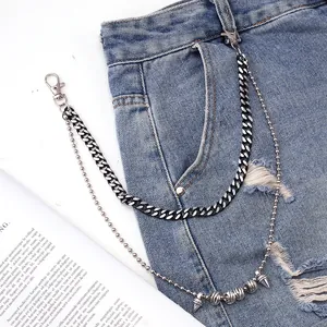 Double-layered punk metal waist chain with silver cone pendants on blue denim jeans