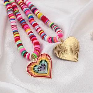 Detailed close-up of rainbow heart pendant and colorful handmade clay beads on silk