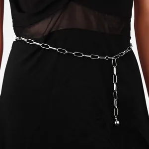 Chaîne de taille argentée à maillons trombone avec pendentif boule sur robe noire