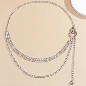 Macro view of silver triple-layered metal body chain featuring heart buckle and pendant