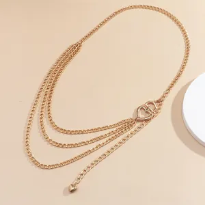 Detail of layered gold body chain featuring overlapping heart buckles and heart charms