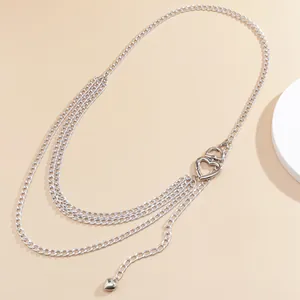 Close-up of silver layered body chain featuring heart-shaped cutouts and curb chain detail