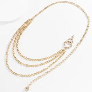 Detail view of multi-layer gold metal waist chain with hollow heart buckle and charms