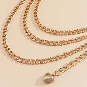 Macro shot of gold layered curb chain body belt featuring a polished solid heart pendant