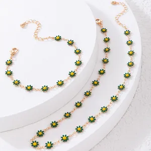 Détail de l'ensemble collier et bracelet marguerite avec pétales verts et chaîne dorée