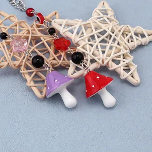 Macro detail of mushroom charm with evil eye beads and colorful resin pendants