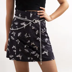 Detail of silver multi-layered chain belt with heart buckle on butterfly print skirt