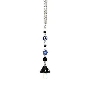 Detailed view of silver chain pendant featuring evil eye bead and polka dot mushroom charm