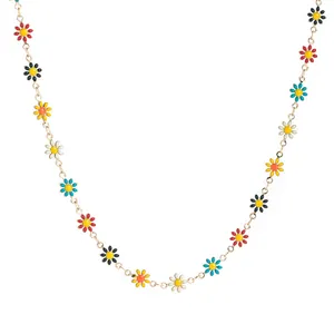 Détails de breloques marguerites colorées en émail sur un collier chaîne dorée
