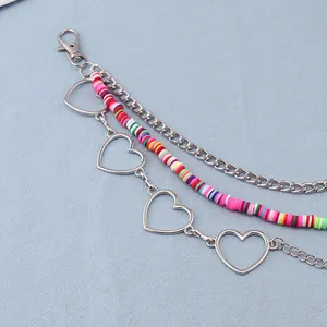 Macro detail of multilayer waist chain with heart links, colorful beads and metal lobster clasp